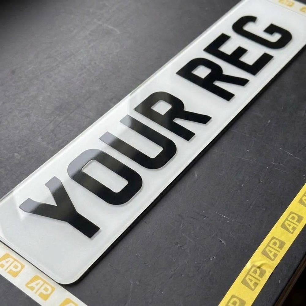 White front 2D number plate close up showing the flat printed characters