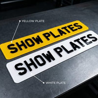 White front and yellow rear 4D show plates side by side, both with raised letters