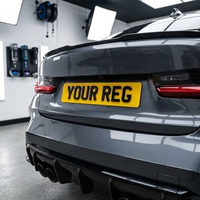Yellow 4D rear number plate fitted to a grey car