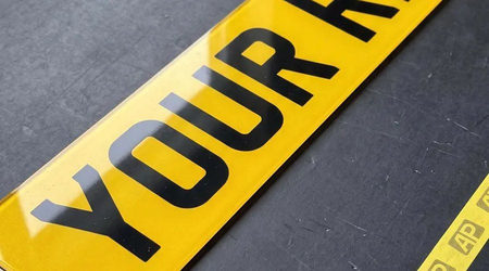 Yellow 2D number plate close up, flat printed characters